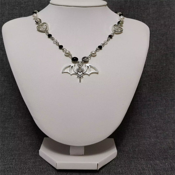 Collar estilo rosario hecho a mano con cuentas de perlas de vidrio blanco y negro y cuentas craqueladas.