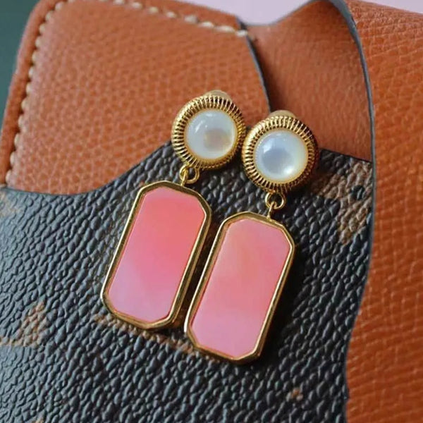 Pendientes rectangulares geométricos con incrustaciones de circonita rosa.