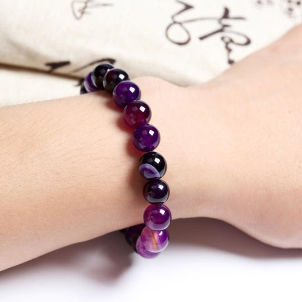 Pulsera elástica de cuentas de ágata con rayas moradas, ideal para la sanación energética.