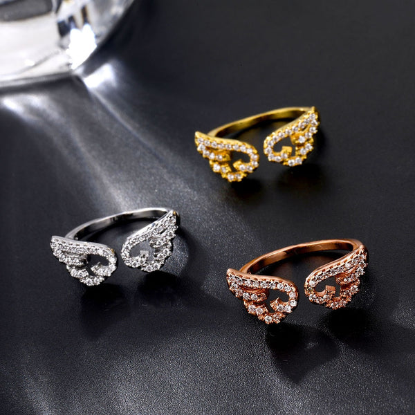 Anillo ajustable con alas de ángel y micro pavé de circonitas doradas.