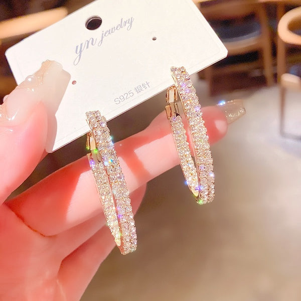 Pendientes de mujer con diamantes de imitación dorados.
