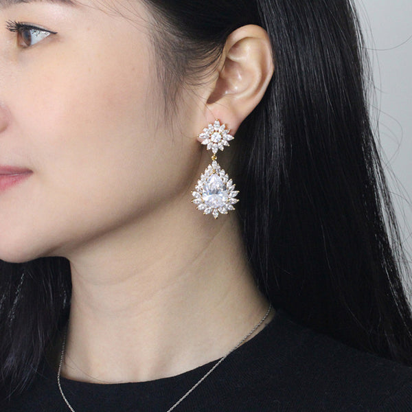 Pendientes largos con forma de gota de agua y circonita cúbica con flor grande en color dorado brillante