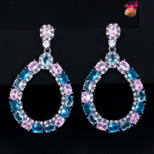 Pendientes largos colgantes redondos de oro negro con circonita cúbica ovalada en azul claro y rosa